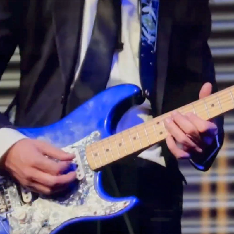 Musician playing a blue electric guitar